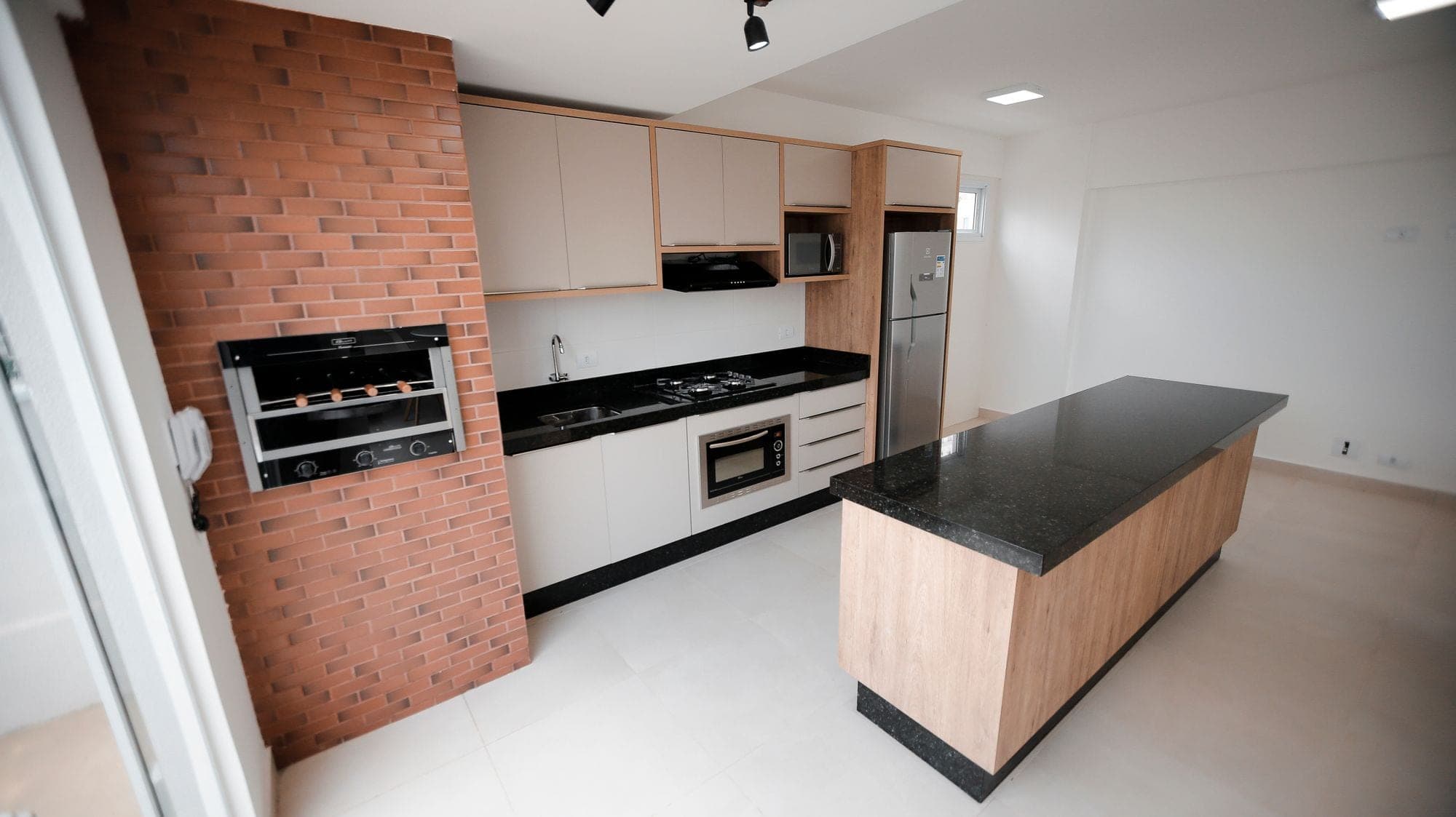 A fitted kitchen with a black granite worktop and island