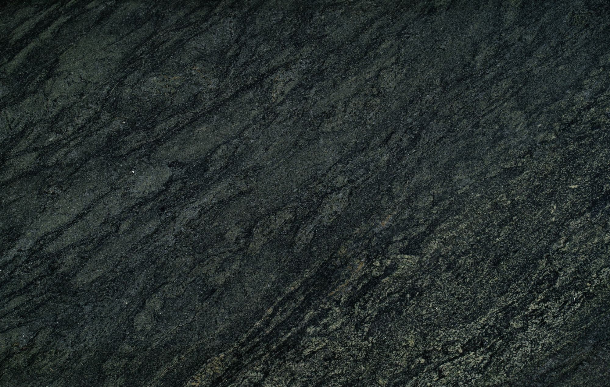 Dark granite slab surface with a diagonal natural grain