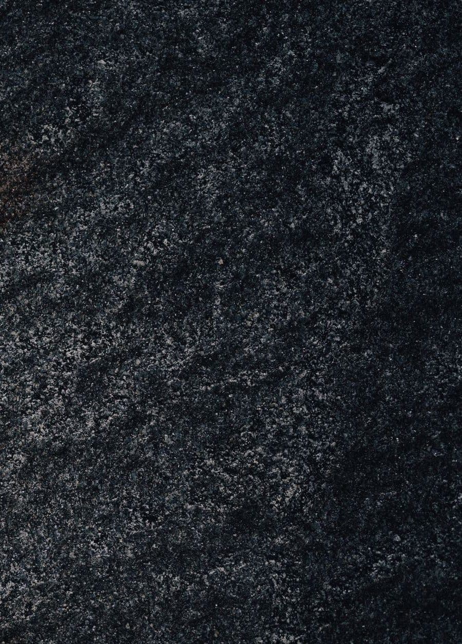 A near-black granite surface with a fine, even grey speckle